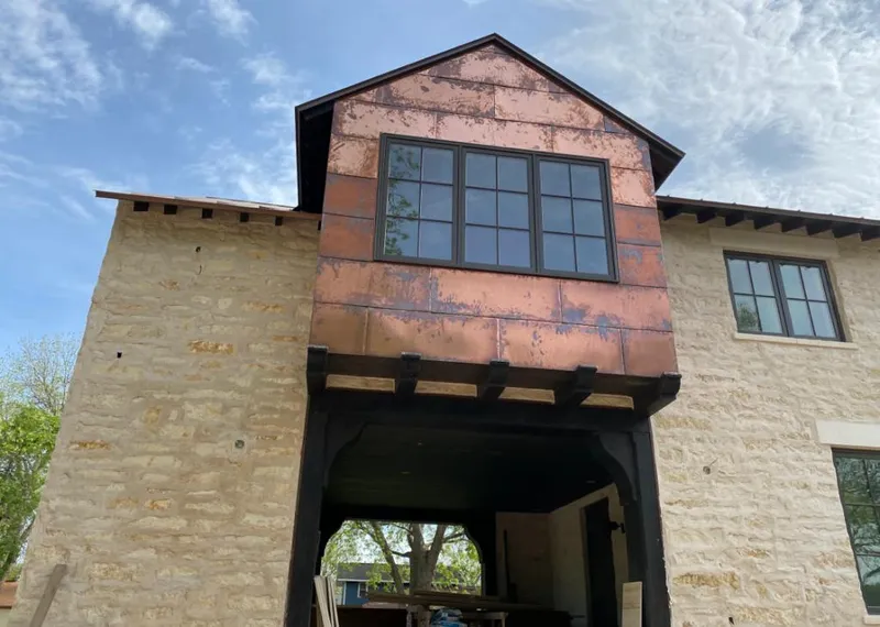 Copper metal panel facade on a stone building for Skylight Installation in Bloomer