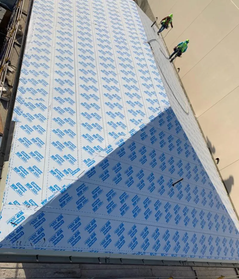 Professional roofers installing underlayment on a metal roof in Bloomer